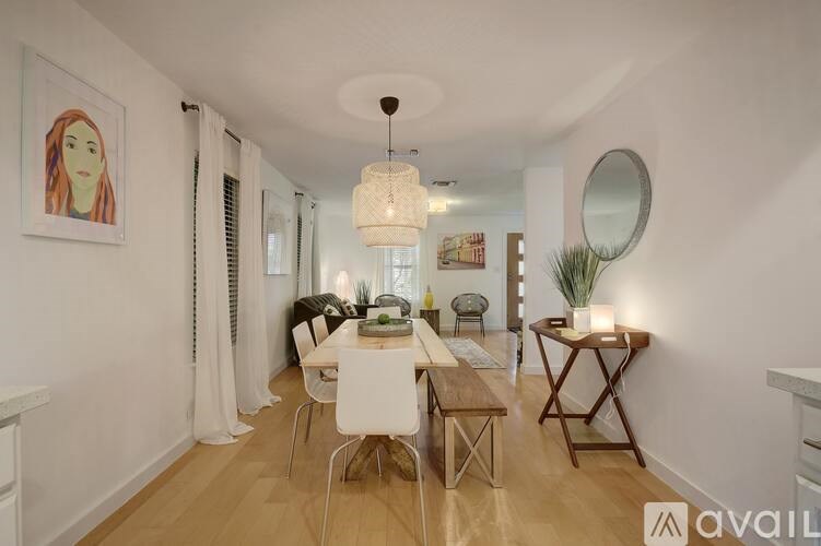 A dining room with a white table and chairs.