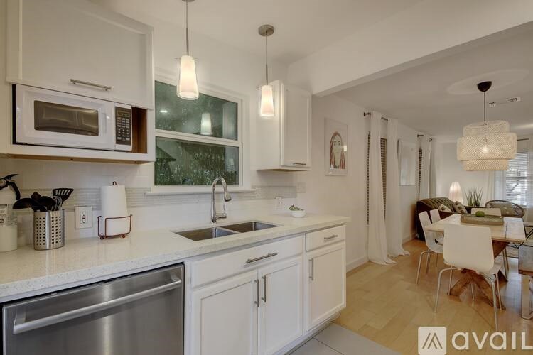 A modern kitchen with white cabinets and stainless steel appliances.