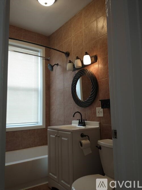 A bathroom with brown tiles and a white sink.