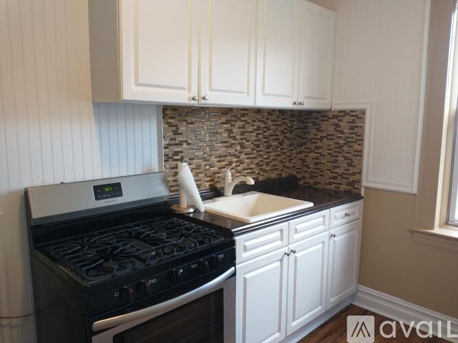 A kitchen with a black stove and white cabinets.