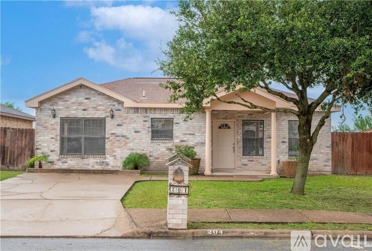 A house with a stone facade and a tree in front.