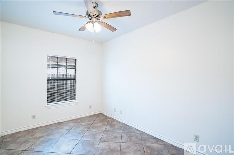 A room with a ceiling fan and a window with blinds.