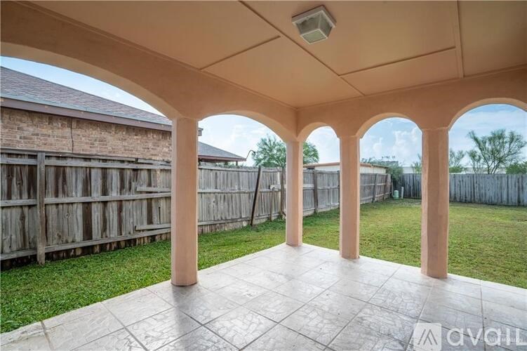 A covered patio area with a tiled floor and wooden pillars.