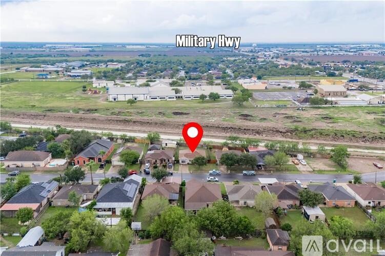 An aerial view of a neighborhood with a red pin marking a specific location.