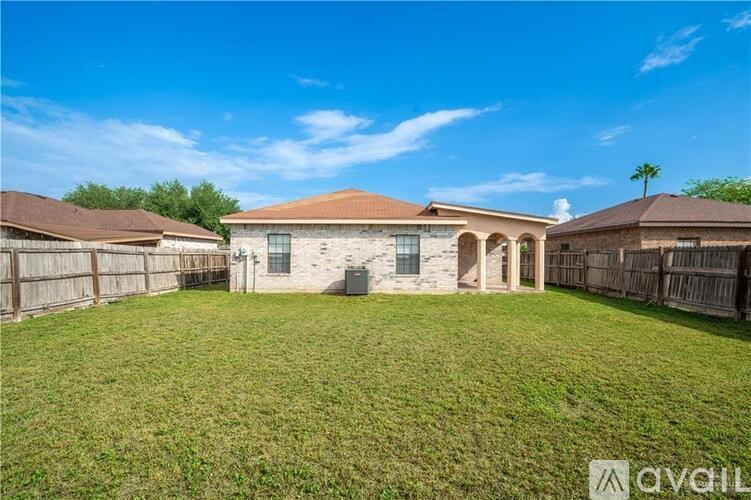 A house with a brown roof and a fence in front of it.