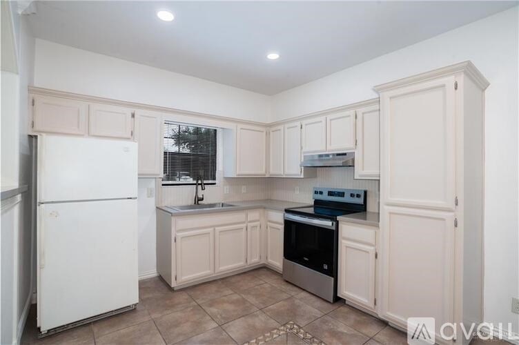 A kitchen with white appliances and cabinets.