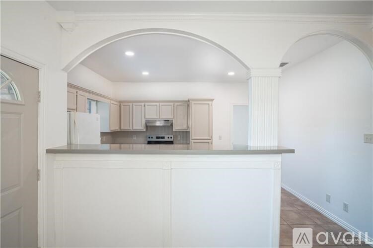 A kitchen with white cabinets and a countertop with a microwave and oven.