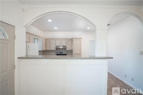 A kitchen with white cabinets and a countertop with a microwave and oven.