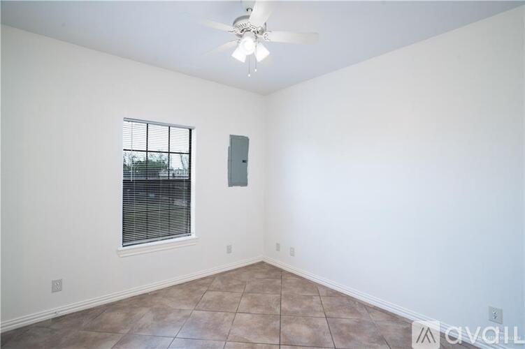Empty room with a window and a ceiling fan.