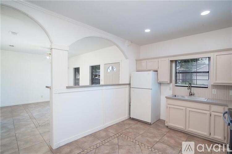 A kitchen with a white refrigerator and cabinets.