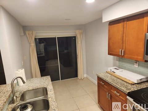 A kitchen with wooden cabinets and a granite countertop.