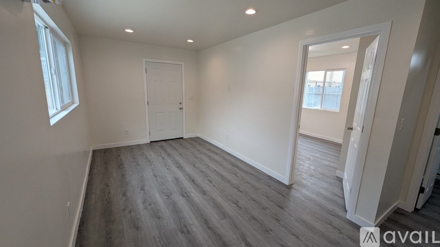 A spacious room with a grey floor and white walls.