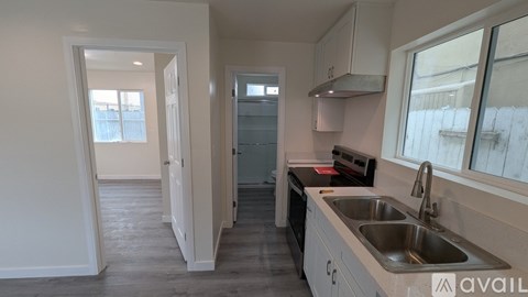 A kitchen with a sink, stove, and cabinets.
