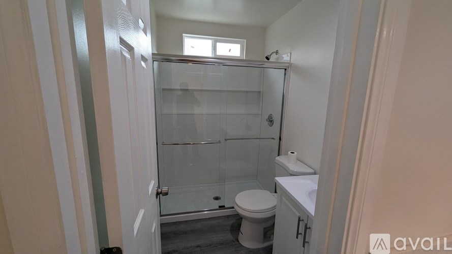 A bathroom with a toilet, sink, and shower.