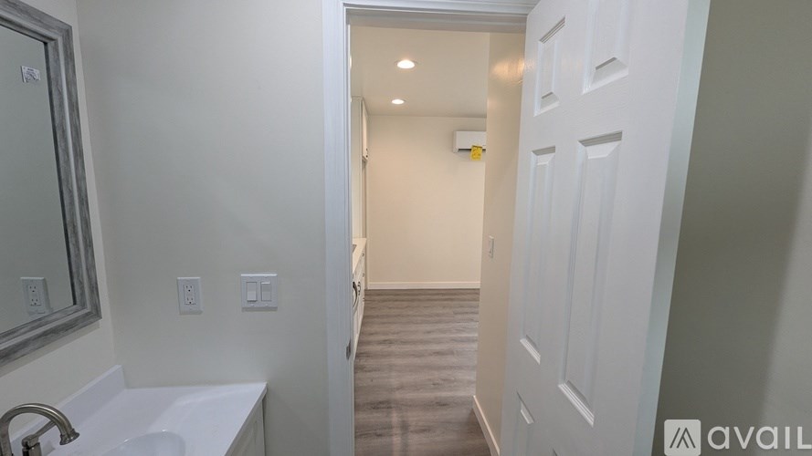 A bathroom with a white sink and a white door.