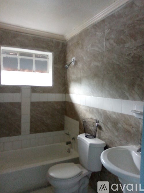 A bathroom with a toilet, sink, and bathtub.