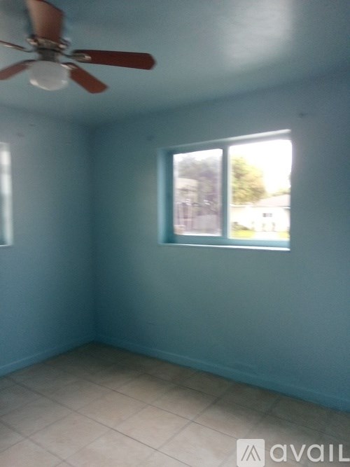 A room with a ceiling fan and a window.