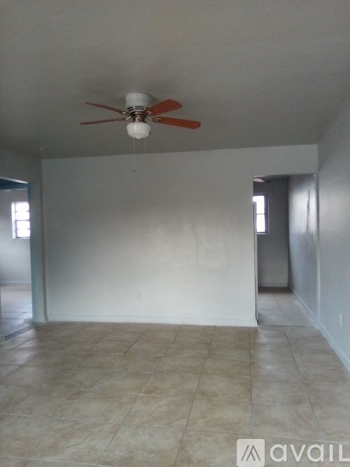 A room with a ceiling fan and tile flooring.