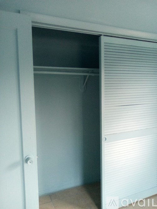 A white door with a shutter on the side is open.
