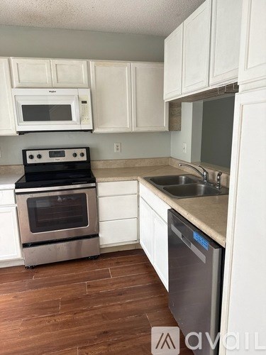 A kitchen with white cabinets and a stainless steel dishwasher.