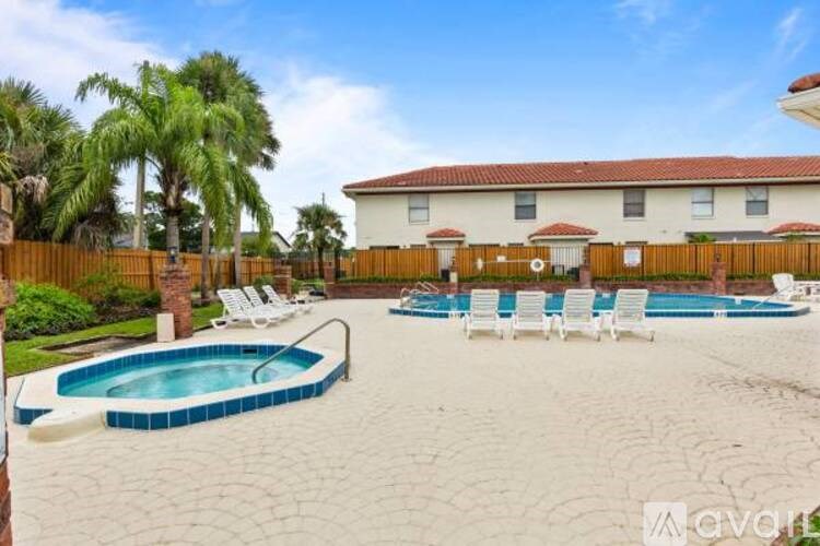 A pool and lounge chairs are set up in a backyard.