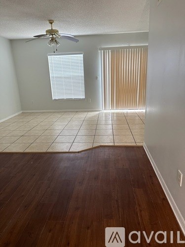 A room with a ceiling fan and a door with blinds.