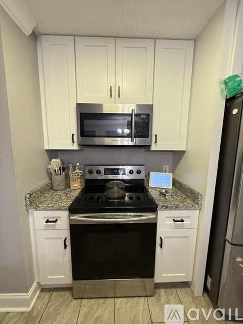 A kitchen with white cabinets and a black stove top.