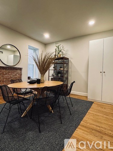 A dining room with a round table and chairs.