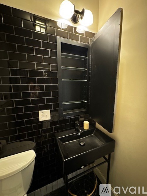 A bathroom with a black vanity and a white toilet.