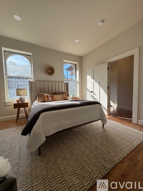 A bedroom with a large bed and a window overlooking a snowy landscape.