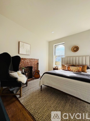 A bedroom with a large bed and a fireplace.