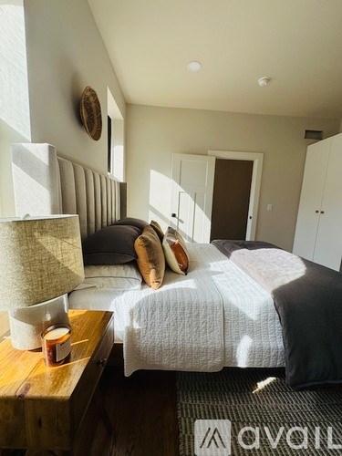 A bedroom with a bed, nightstand, and a wall clock.