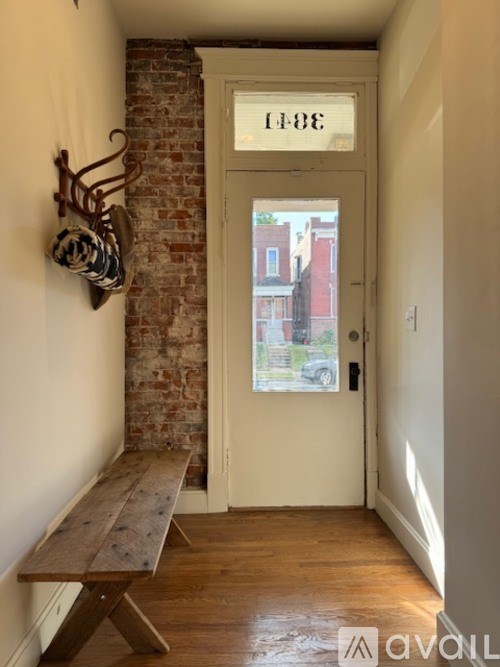 A hallway with a bench and a door with a number on it.