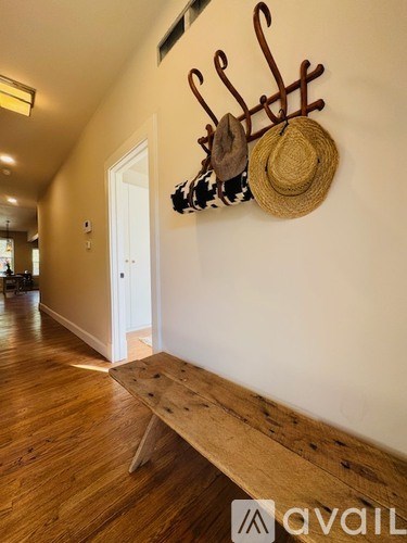 A wall-mounted rack with hats and a hat stand.