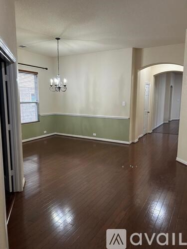 A room with wooden floors and a chandelier.