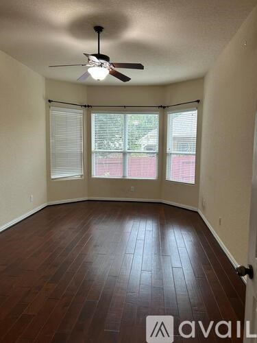 A room with a ceiling fan and sliding glass doors.