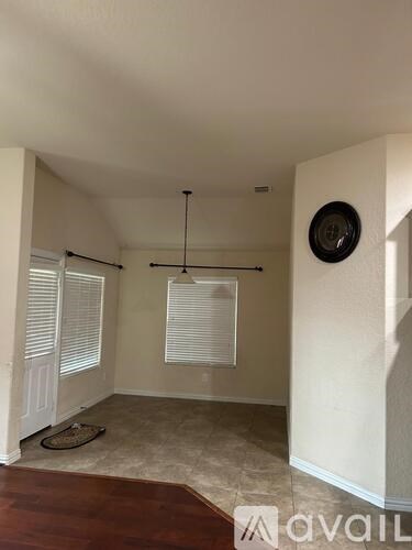 A room with a brown rug and a clock on the wall.