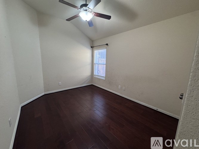A room with a ceiling fan and wooden flooring.