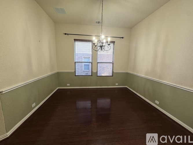 A room with wooden floors and a window with blinds.