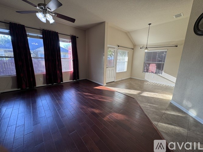 A room with a ceiling fan and wooden flooring.