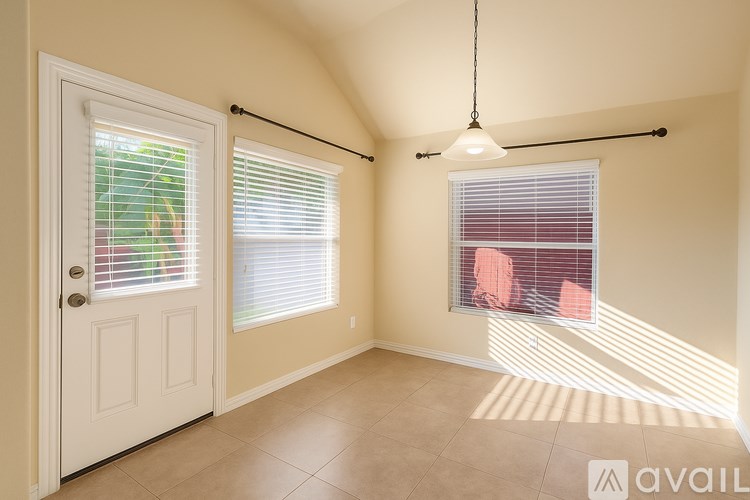 A room with a door, a window with blinds, and a hanging light fixture.