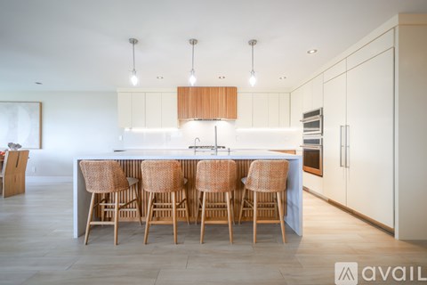 A modern kitchen with a bar area and chairs.