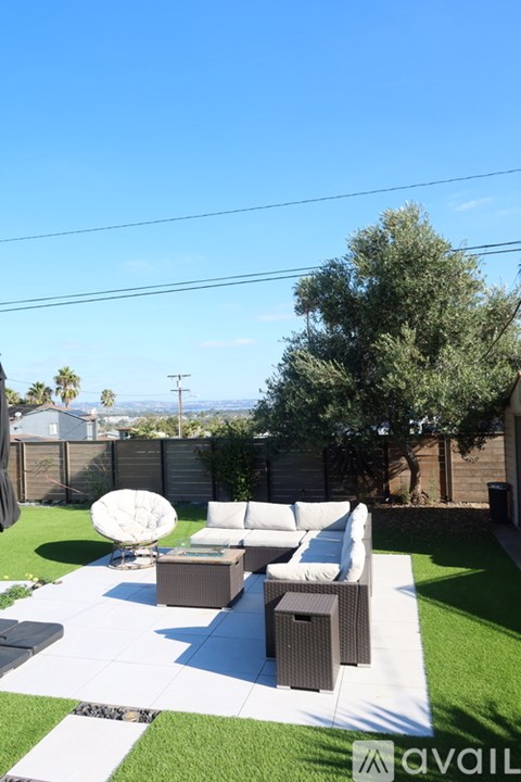 A patio with a white couch and a brown table.