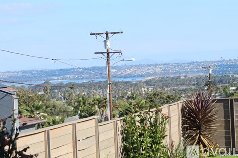 A view of a city from a residential area with a utility pole in the foreground.