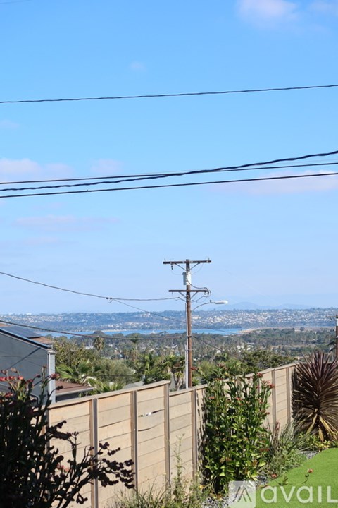 A view from a house with a fence and a power line.