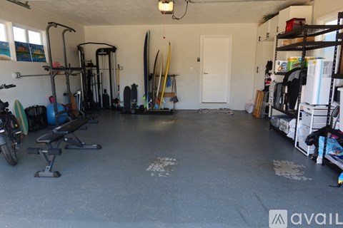 A garage with a variety of equipment and surfboards.