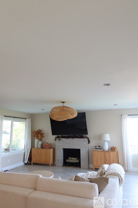 A living room with a fireplace and a white couch.