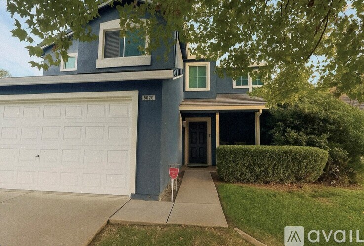 A house with a blue exterior and a white garage door.