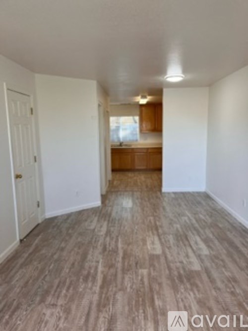 A room with wooden flooring and white walls.