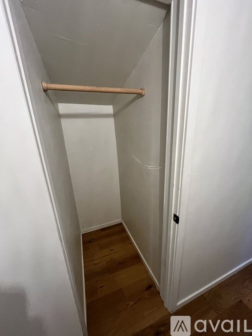 A white door with a wooden handle is open.